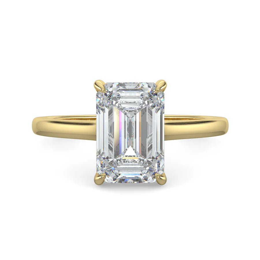 Top view of a gold lab grown diamond ring with radiant-cut diamond in a four-prong setting and gold color polished band.