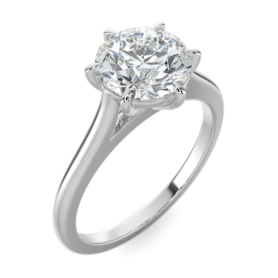 Angled top view of a cathedral-style solitaire engagement ring in white gold, showcasing a round white diamond held by six prongs.