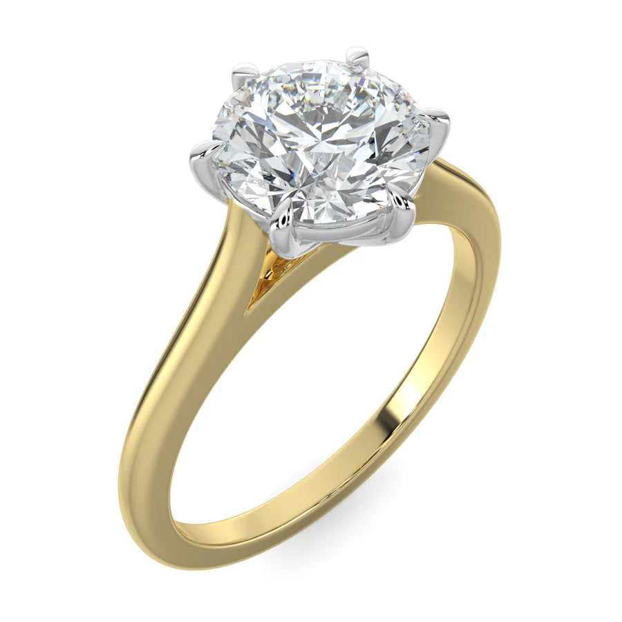 Angled top view of a cathedral-style solitaire engagement ring in yellow gold, featuring a round white diamond held by six prongs. 