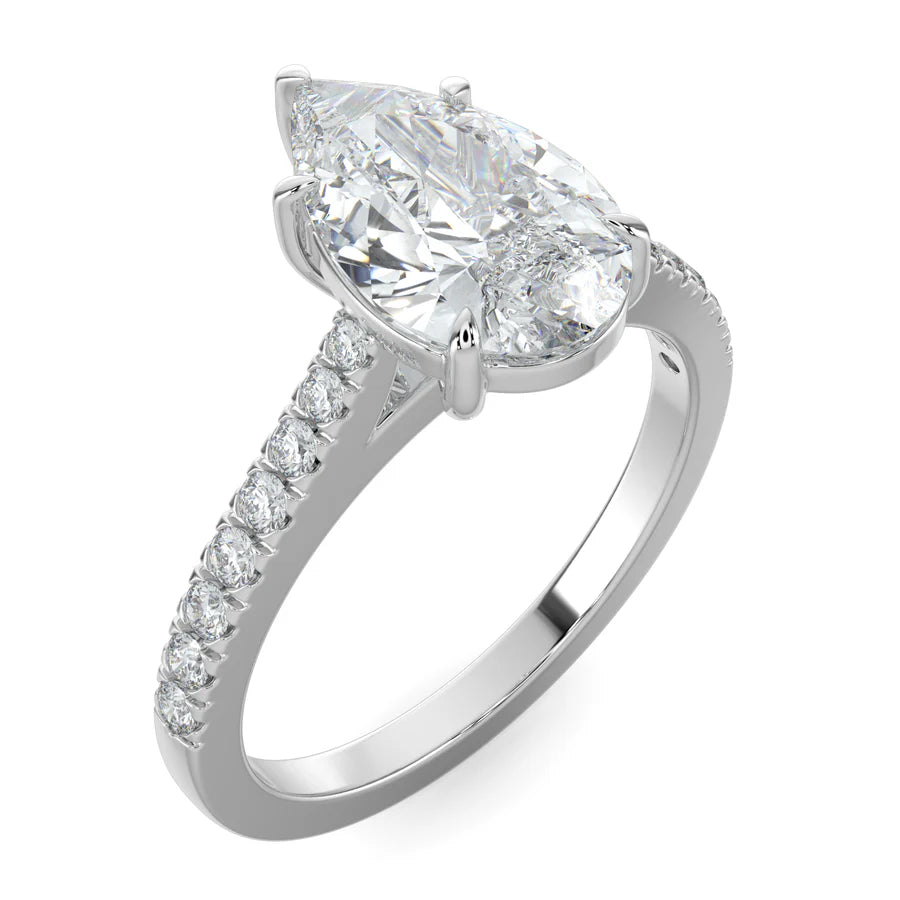 Angled view of a silver lab diamond ring featuring small diamonds on the band and a larger pear shaped central diamond in five prong setting.