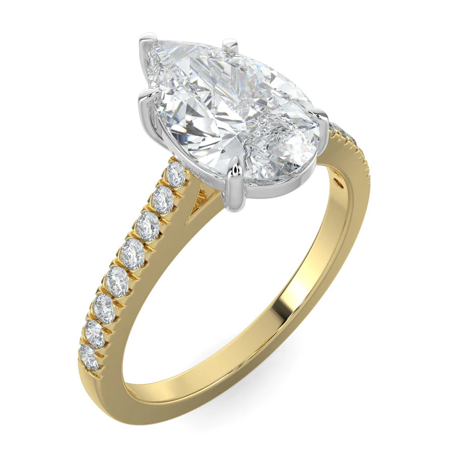 Angled view of a gold lab diamond ring featuring small diamonds on the band and a larger pear shaped central diamond in silver color five prong setting.