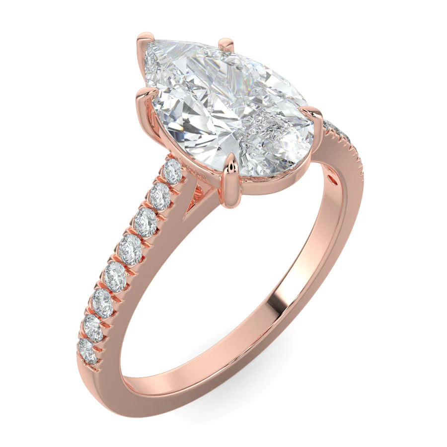 Angled view of a rose gold lab diamond ring featuring small diamonds on the band and a larger pear shaped central diamond in five prong setting.