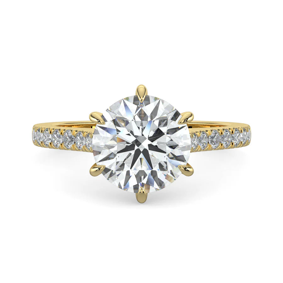 A round lab diamond ring in gold color featuring small diamonds on the band and a larger central diamond in six prong setting.