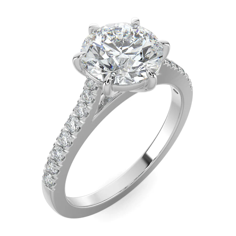 Angled view of a round lab diamond ring in silver color featuring small diamonds on the band and a larger central diamond in six prong setting.