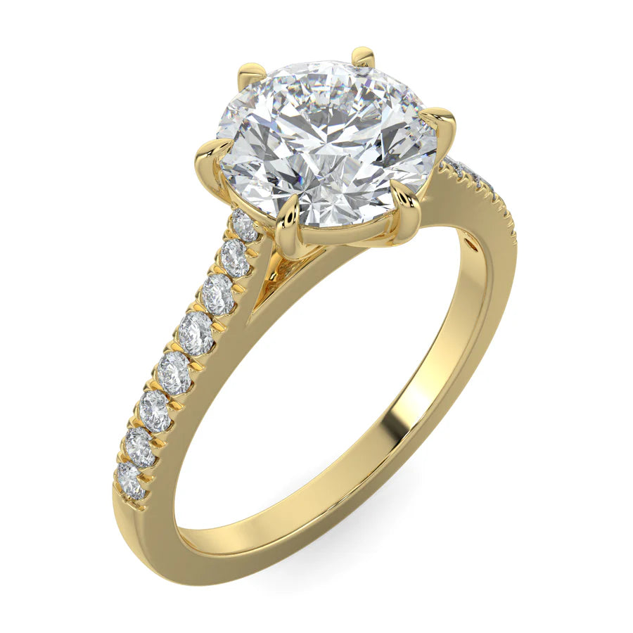 Angled view of a round lab diamond ring in gold color featuring small diamonds on the band and a larger central diamond in six prong setting.